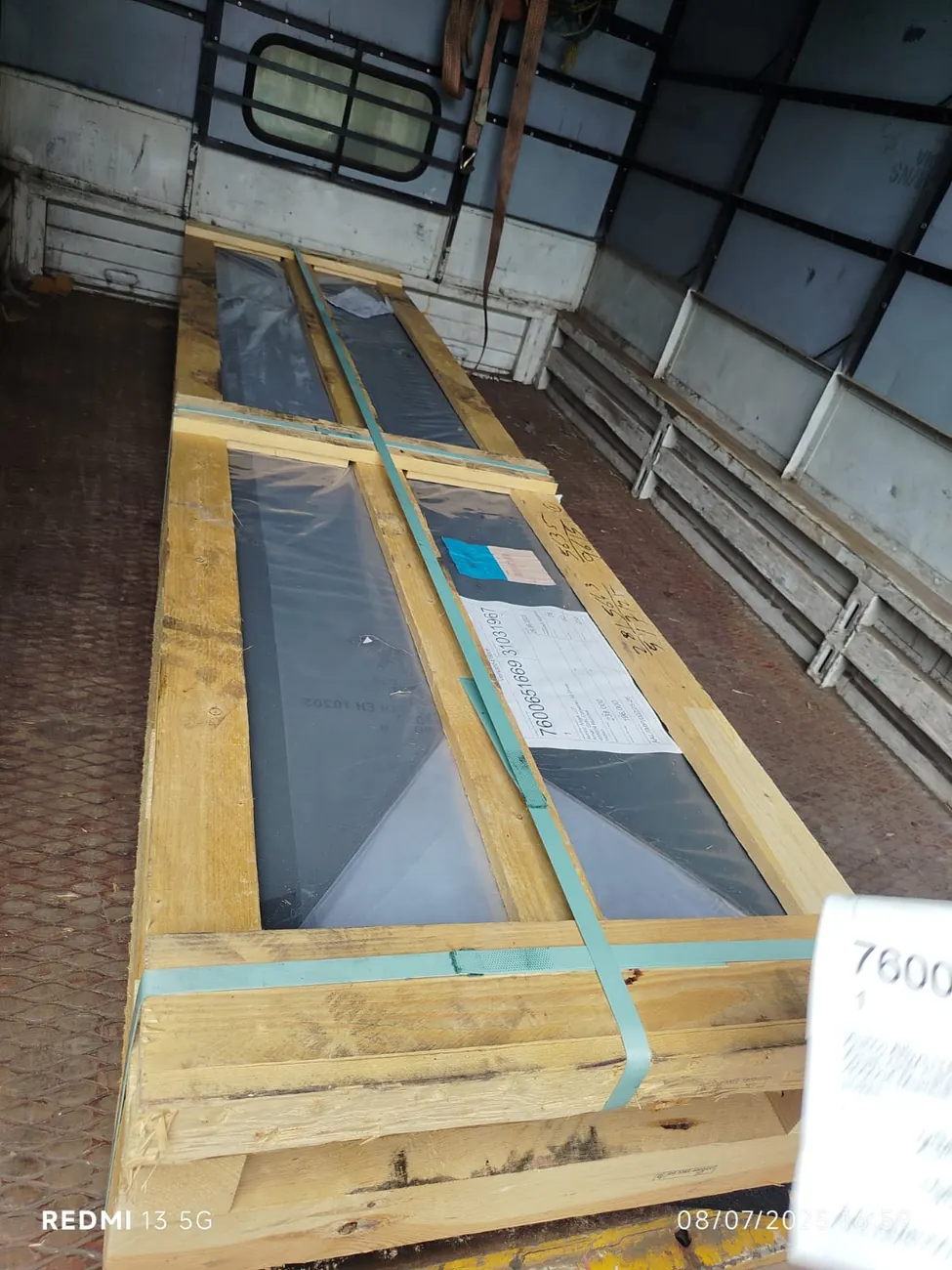 Crated nickel alloy sheets strapped inside a truck, wrapped in polythene with packing list attached